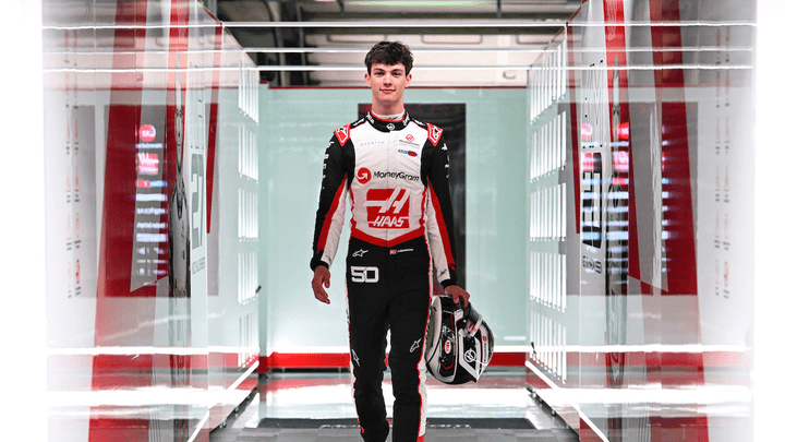 Ollie Bearman en combinaison Haas F1 marchant dans le paddock avec son casque