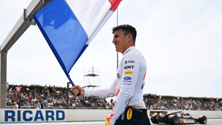 Pilote Red Bull célébrant sa victoire avec le drapeau français au circuit Paul Ricard