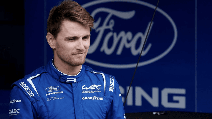 Logan Sargeant en combinaison Ford devant le logo de l'équipe