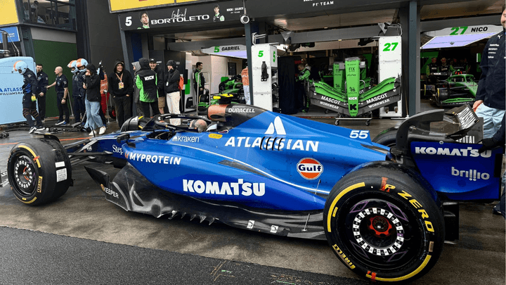 Monoplace Williams F1 bleue #55 dans les stands avec sponsors Komatsu et Gulf visible