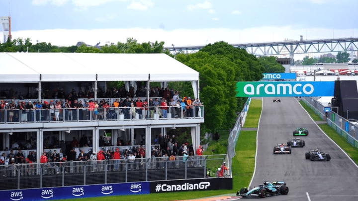 Voitures de Formule 1 en course sur le circuit du GP du Canada avec skyline de Montréal en arrière-plan