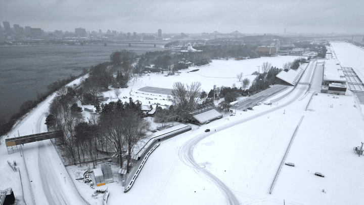 Circuit de F1 recouvert de neige avec virages et infrastructures enneigés, vue aérienne