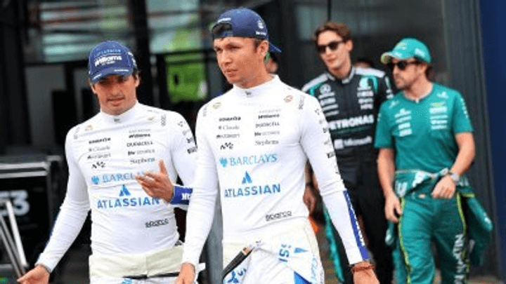 Pilotes Williams en combinaison blanche marchant dans le paddock F1