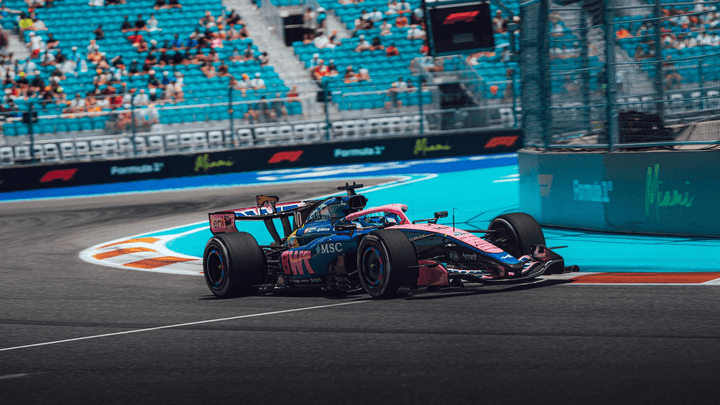 Voiture Alpine F1 en action sur le circuit de Miami avec la livrée rose et bleue caractéristique