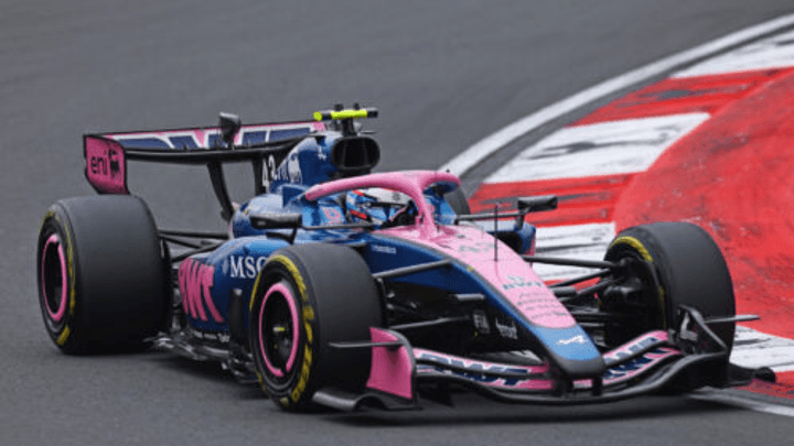 Voiture Alpine F1 rose et bleue sur circuit, vue de trois-quarts avant