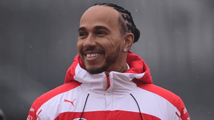 Lewis Hamilton souriant en tenue Ferrari rouge et blanche