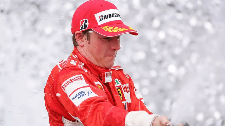 Kimi Räikkönen en combinaison Ferrari rouge sur le podium avec champagne