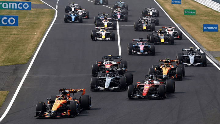 Groupe de voitures de Formule 1 en action sur circuit lors d'une course avec dépassements multiples