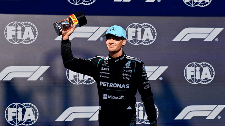 George Russell sur le podium avec son trophée, célébrant sa pole position au sprint qualifying