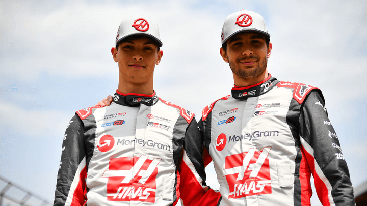 Les pilotes Haas F1 posent ensemble en combinaison officielle rouge et blanche de l'équipe