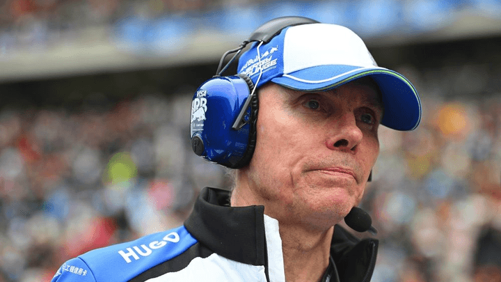 Membre de l'équipe F1 avec casque radio et casquette blanche et bleue sur circuit