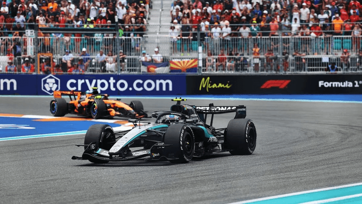 Voiture de F1 Mercedes argentée en action sur circuit avec spectateurs en arrière-plan