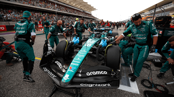Équipe Aston Martin travaillant sur la monoplace verte dans les stands lors d'un arrêt au stand en Formule 1