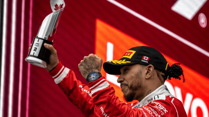 Pilote F1 célébrant sa victoire avec un trophée sur le podium du Grand Prix du Canada