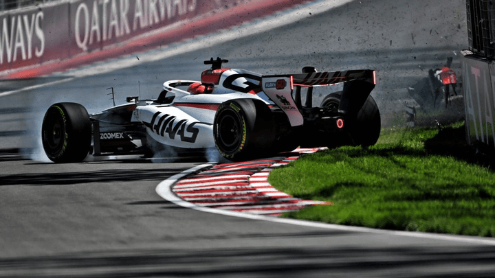 Monoplace Haas F1 blanche et noire avec logos Haas sur circuit, virage avec bordures rouges